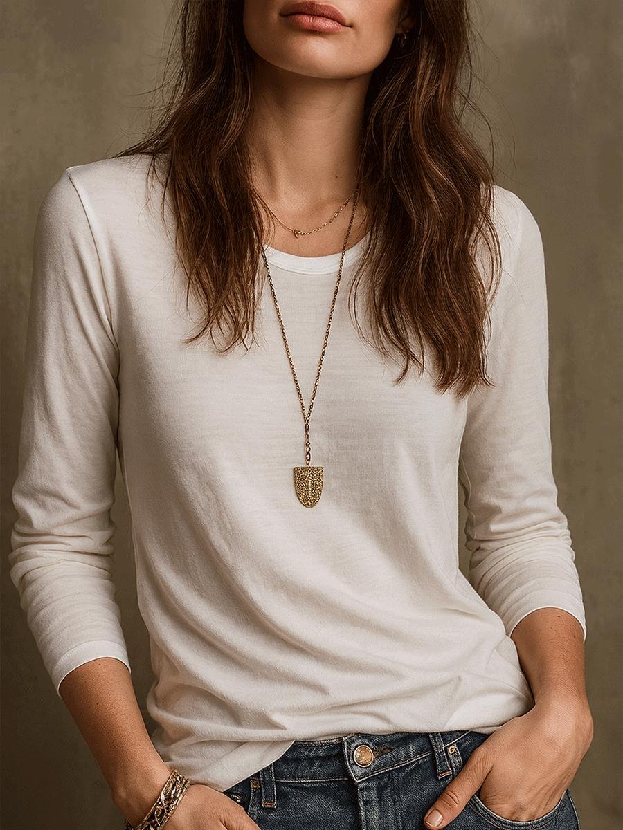 Woman wearing a white tee and jeans with layered gold celestial necklaces