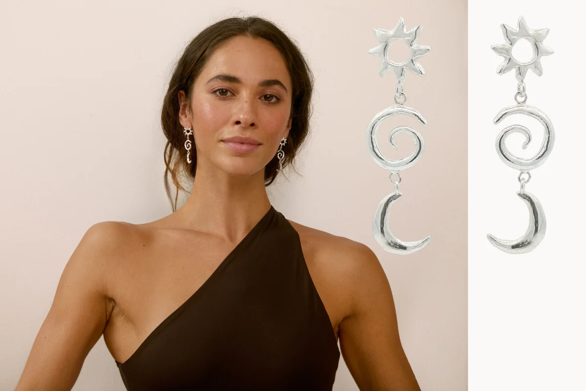 Woman wearing a cocktail dress with mismatched sun and moon earrings
