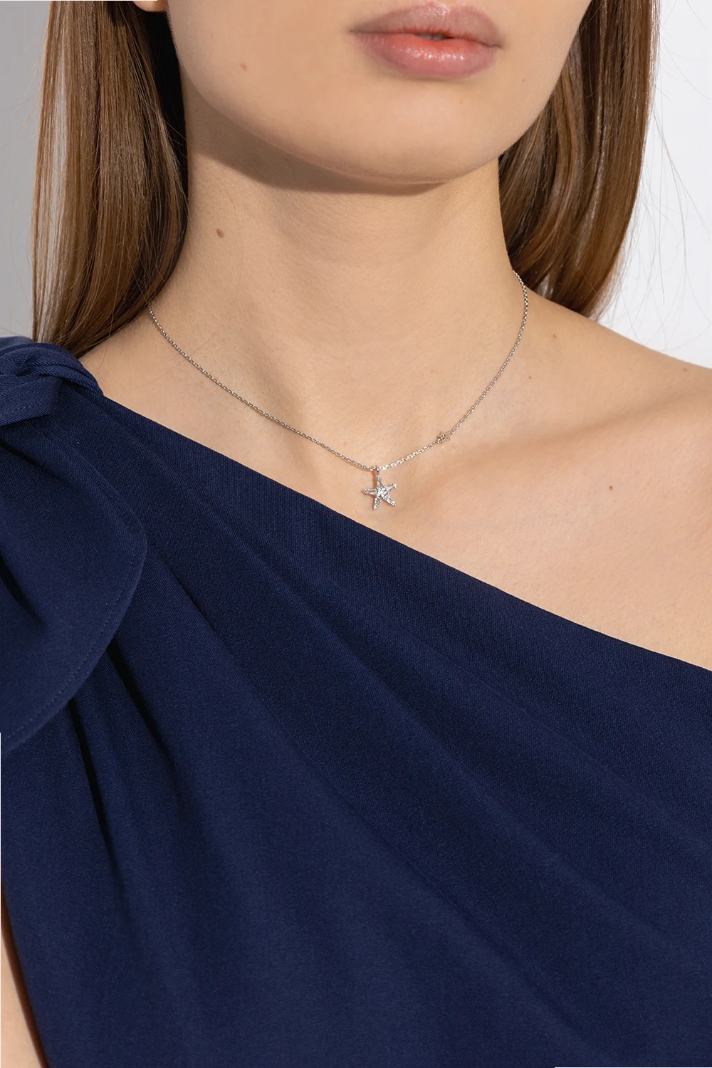 Woman wearing a navy dress with silver star jewelry