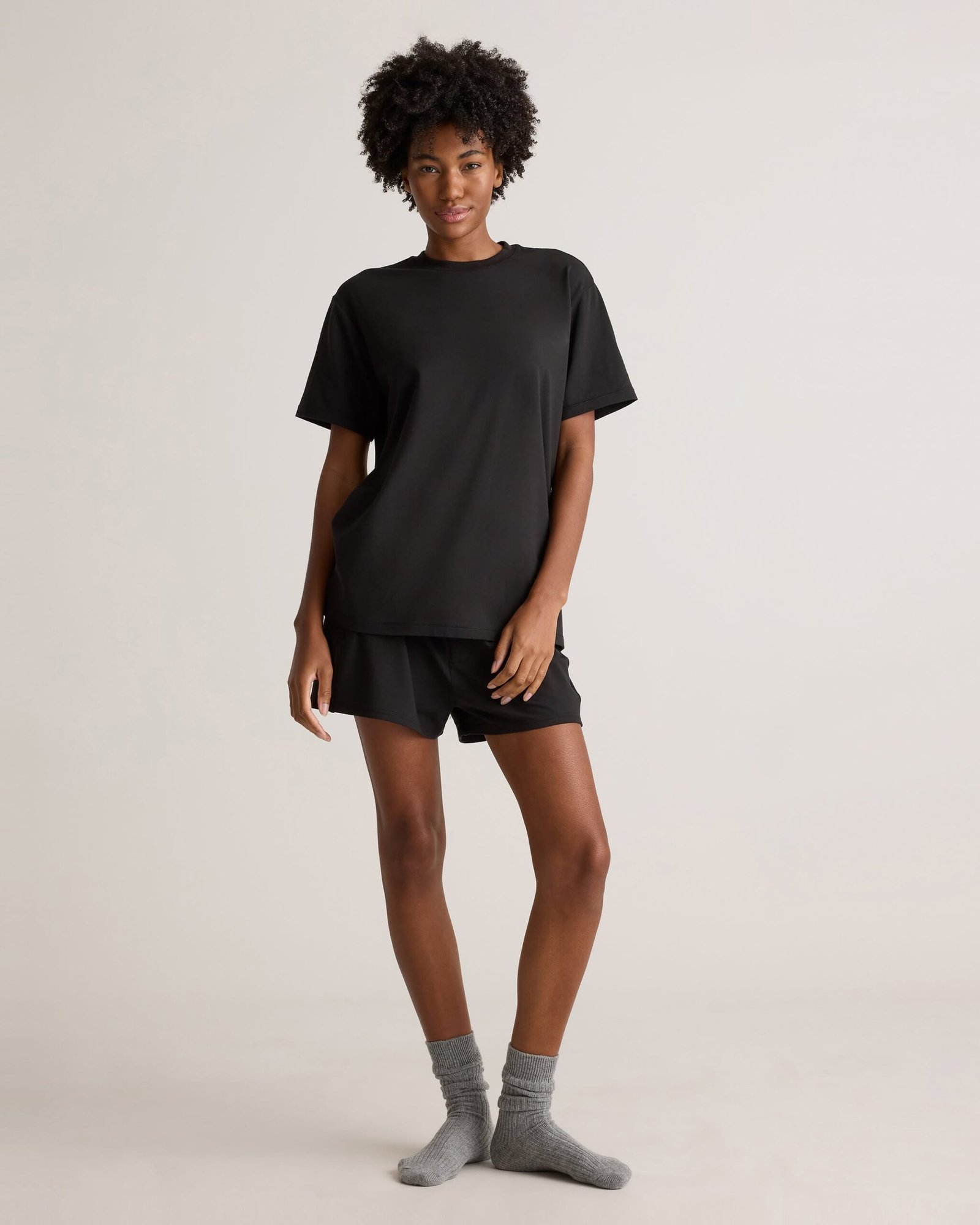 Woman wearing oversized t-shirt with sweat shorts and cozy socks