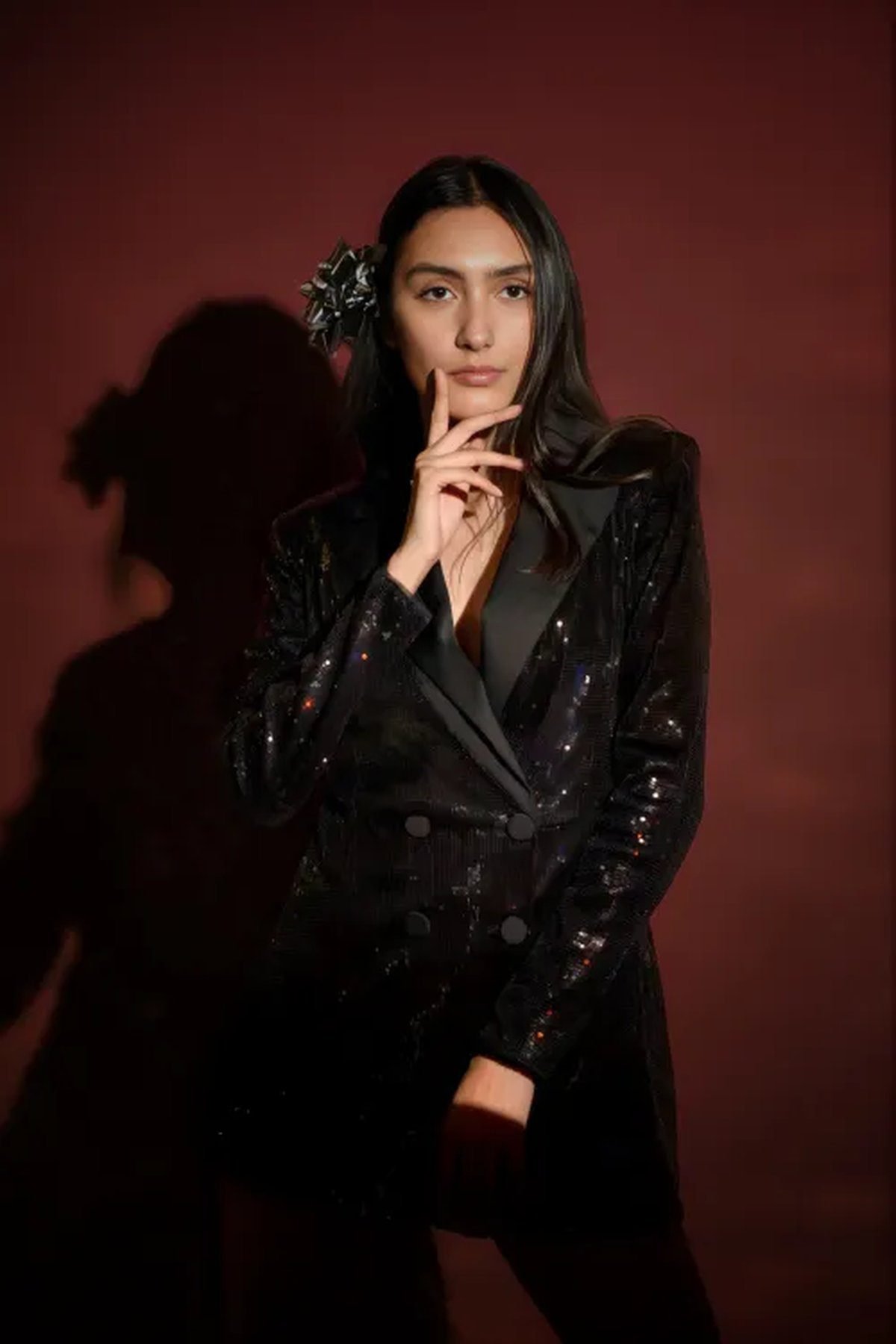 Woman wearing a sequin blazer over a simple black midi dress