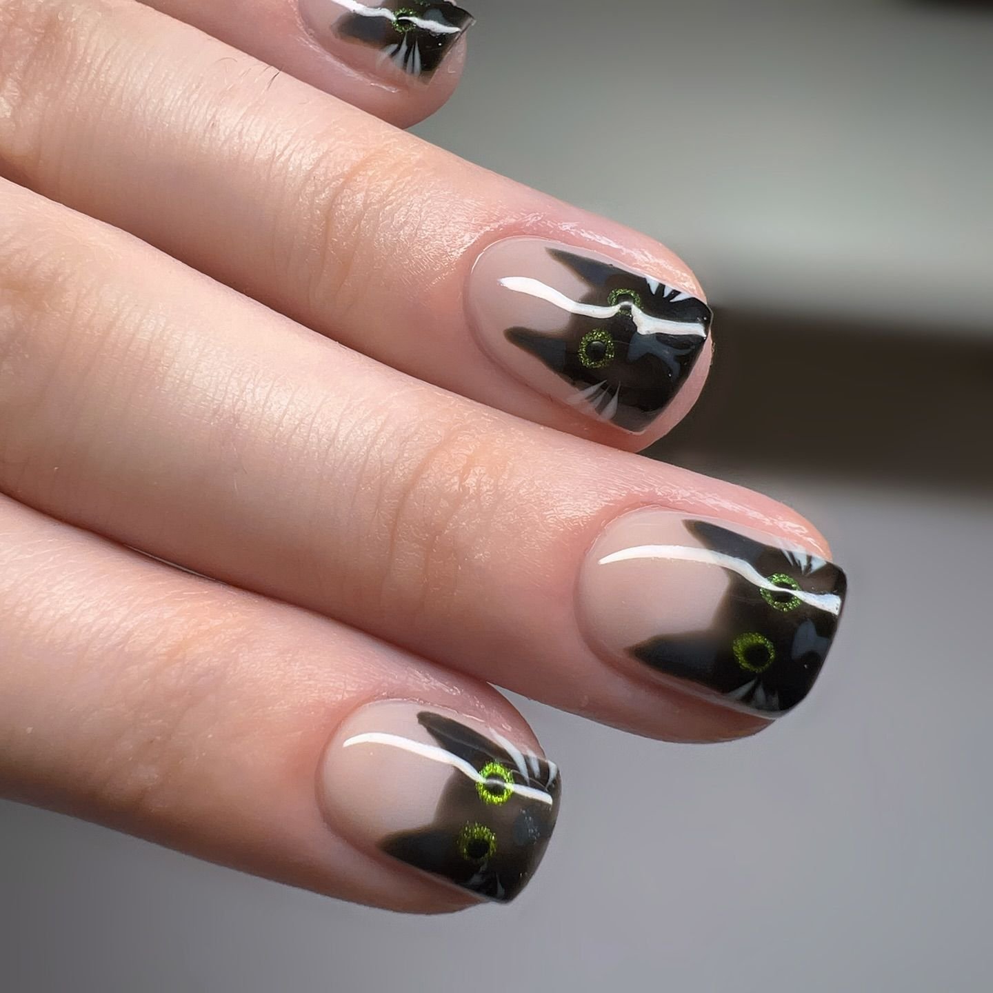 Black cat nail designs for Halloween with silhouette art on nude base