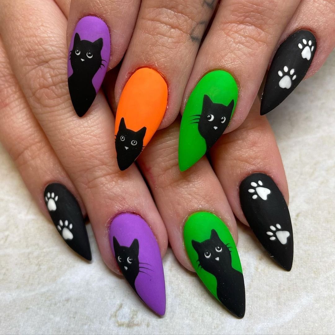 Gothic black cat Halloween nails with glowing red eyes