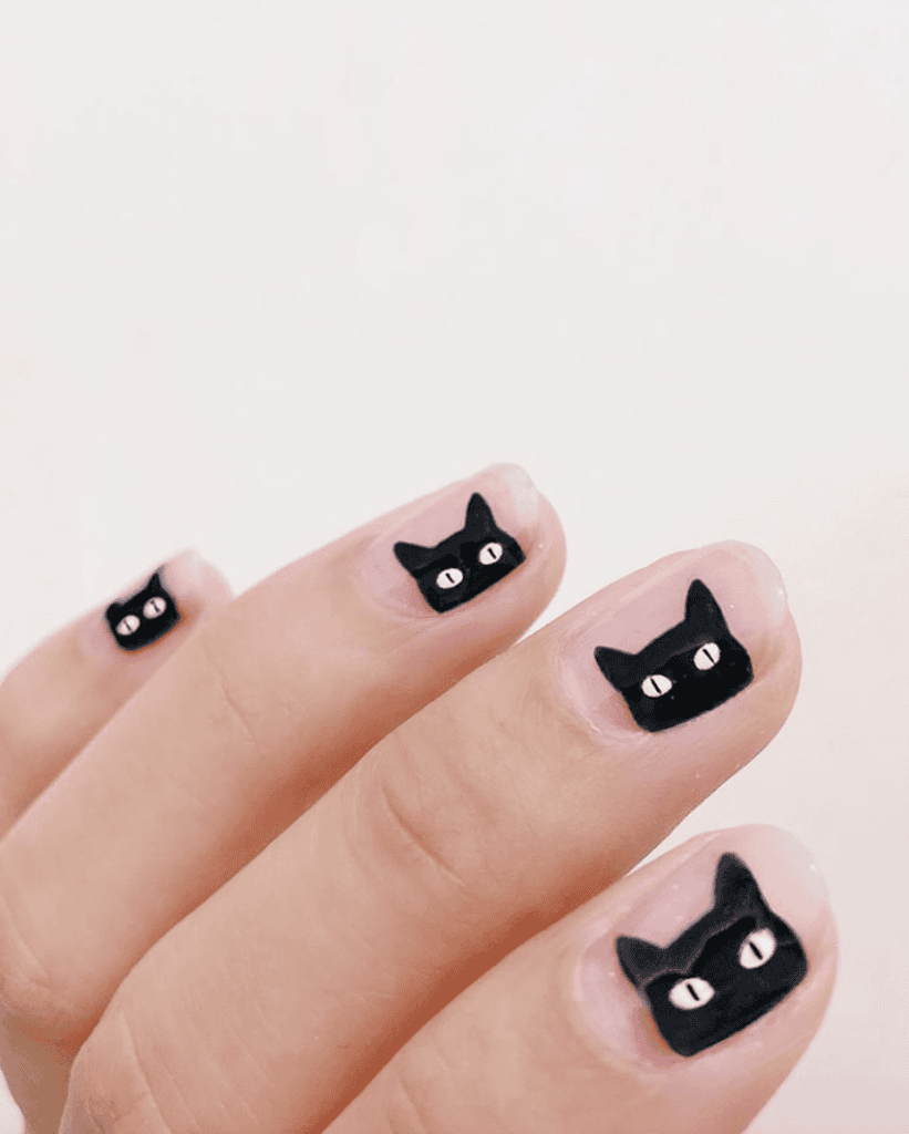 Black cat silhouette on glitter orange Halloween nails