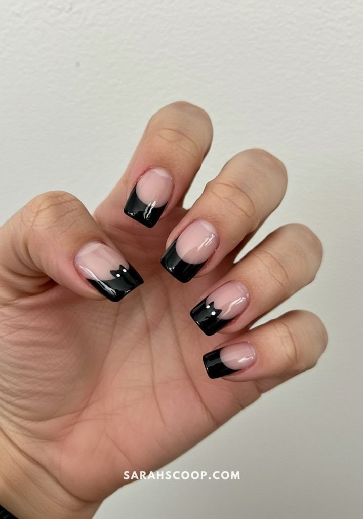 White ghost faces on black Halloween nails