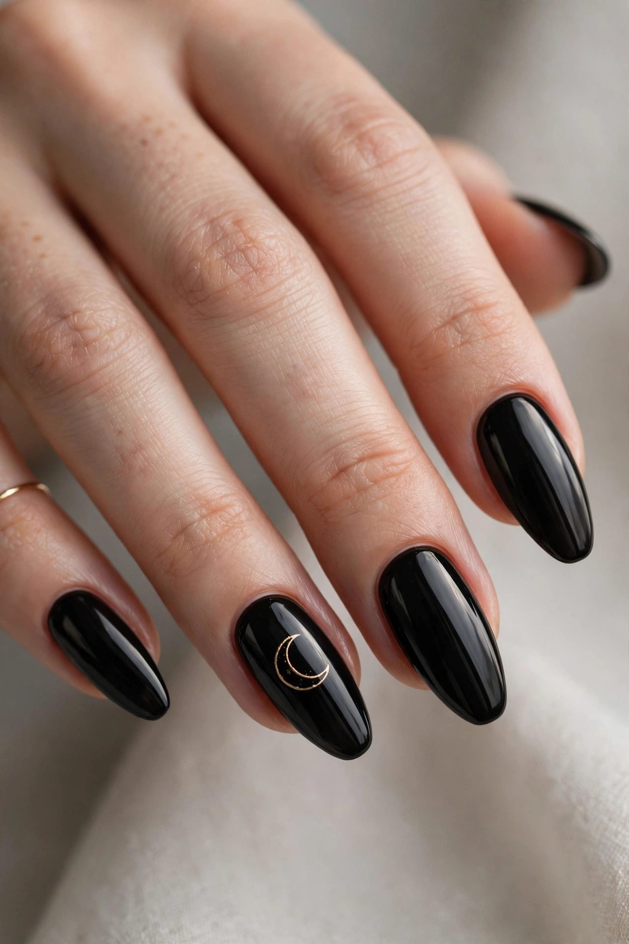 Gold crescent moon nail art on black nails minimalist