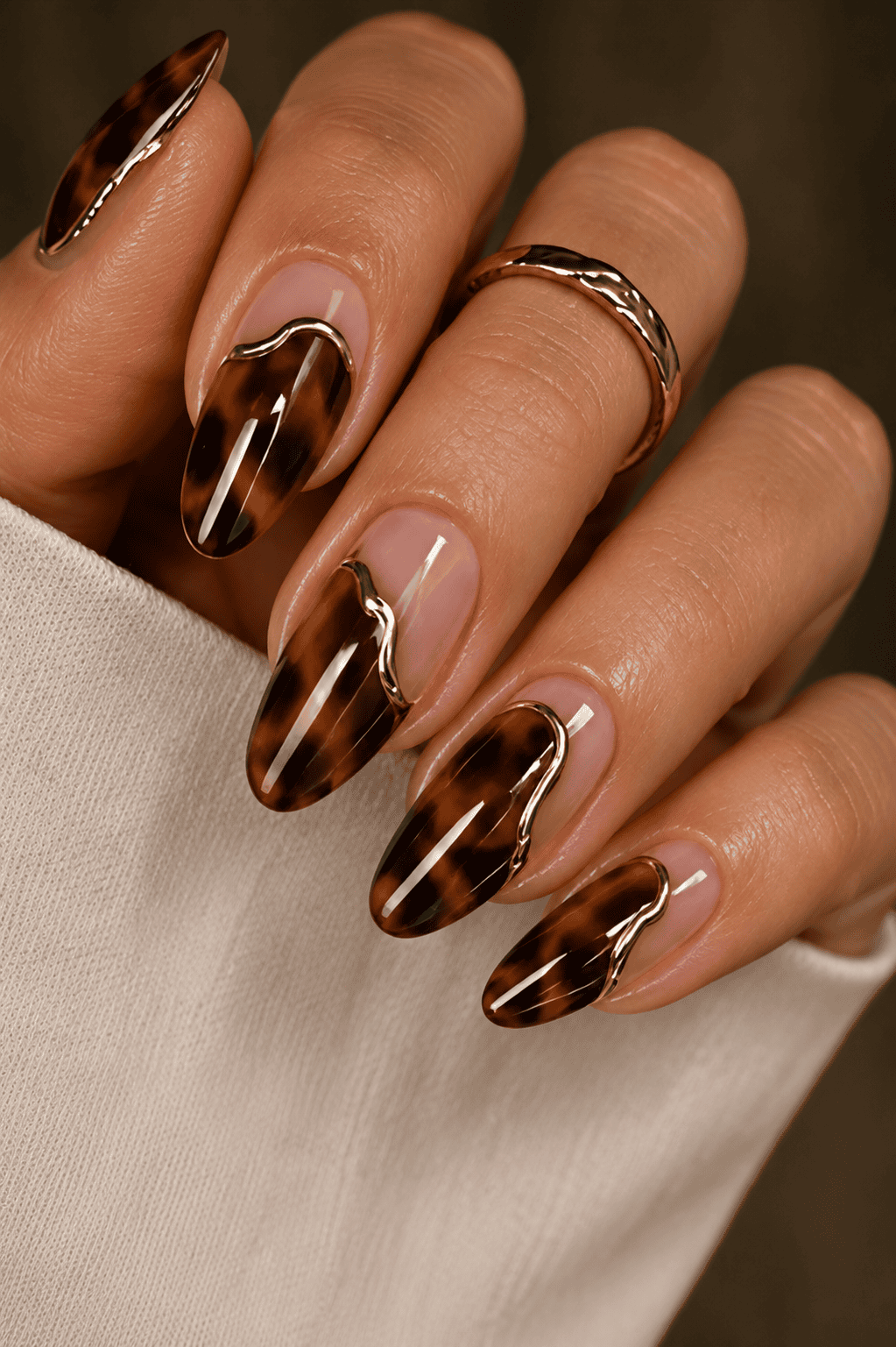Tortoiseshell nail art with gold accent lines