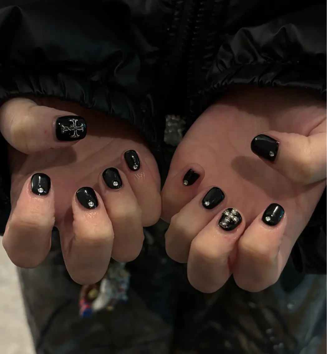 Nude nails with tiny black cross nail art accents