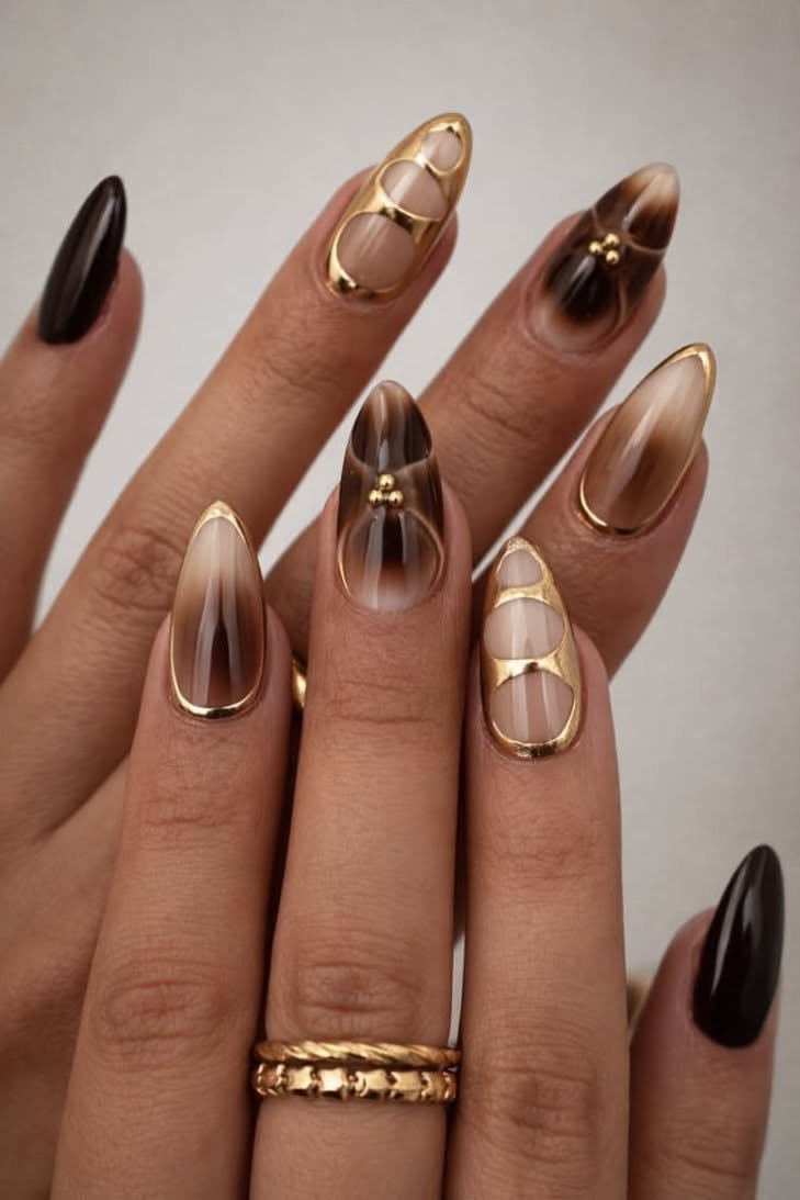 Negative space nails with brown and gold arrow designs