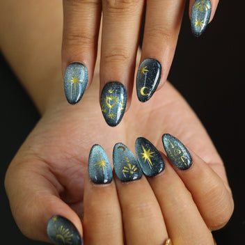 Black cat eye magnetic nails with gold star accents