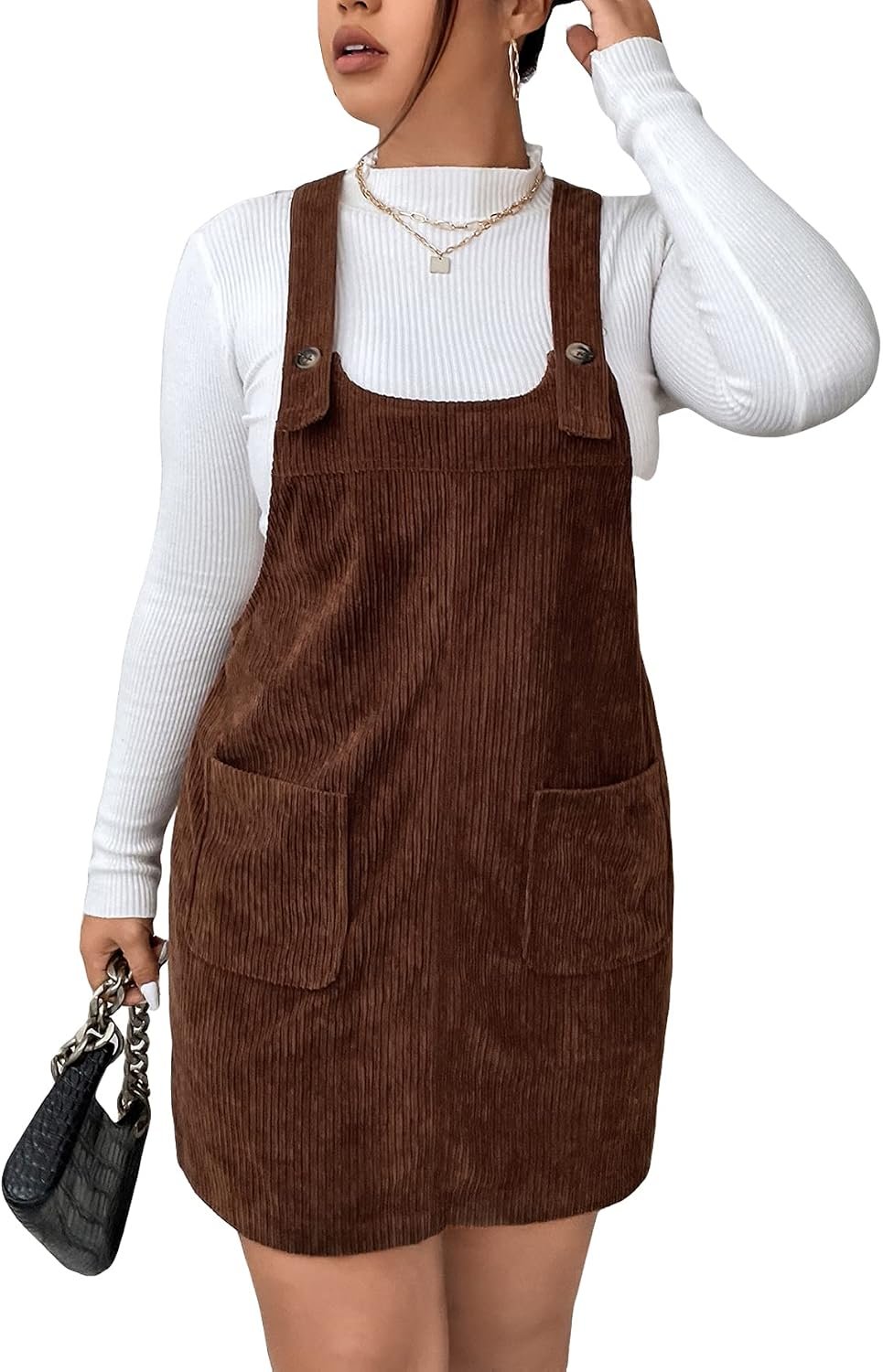 Plus size woman wearing a corduroy pinafore dress over a turtleneck