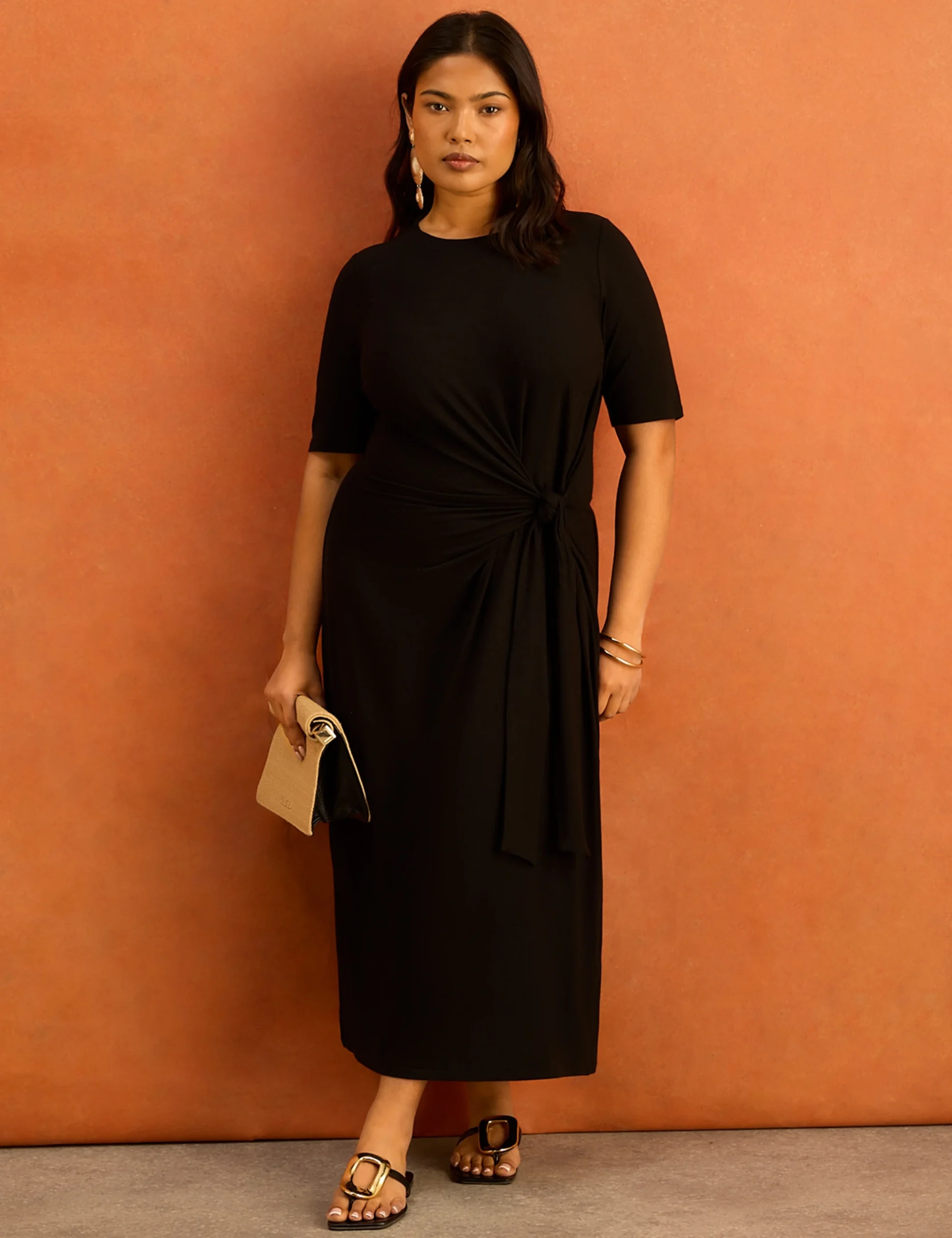 Curvy woman wearing a tie-waist jersey midi dress