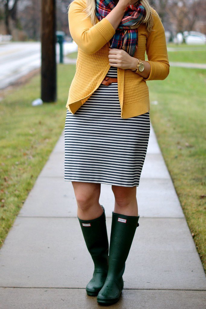 Woman wearing a midi skirt with tall rain boots for work