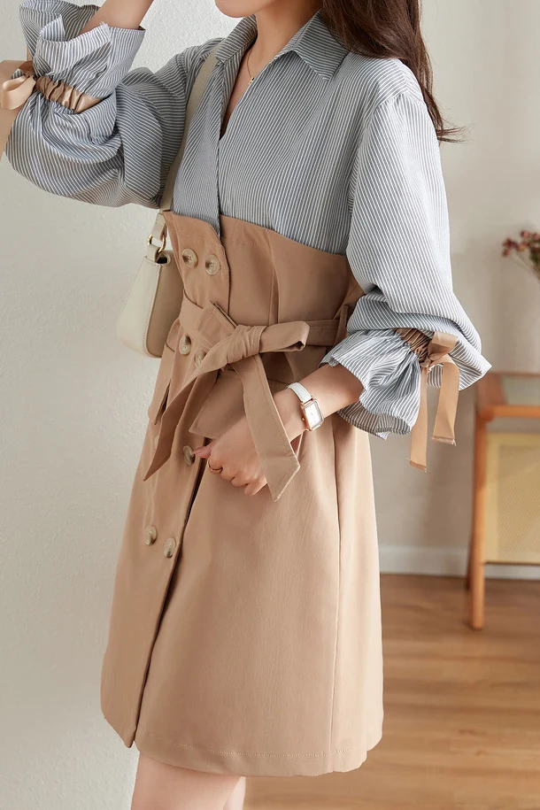 Woman wearing a shirt dress with a belted raincoat