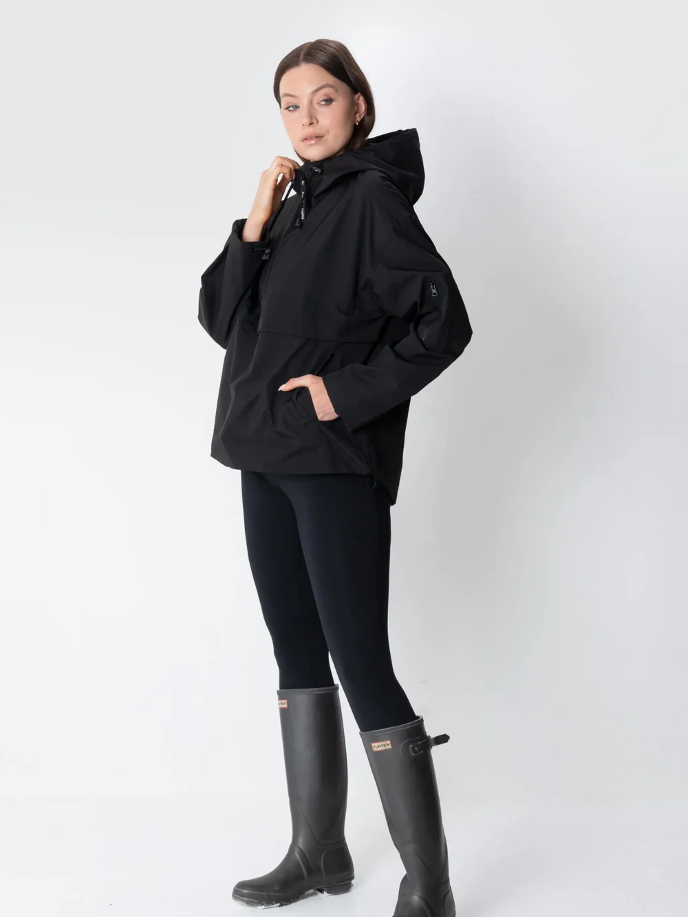 Woman wearing an oversized hoodie with leggings and rain boots