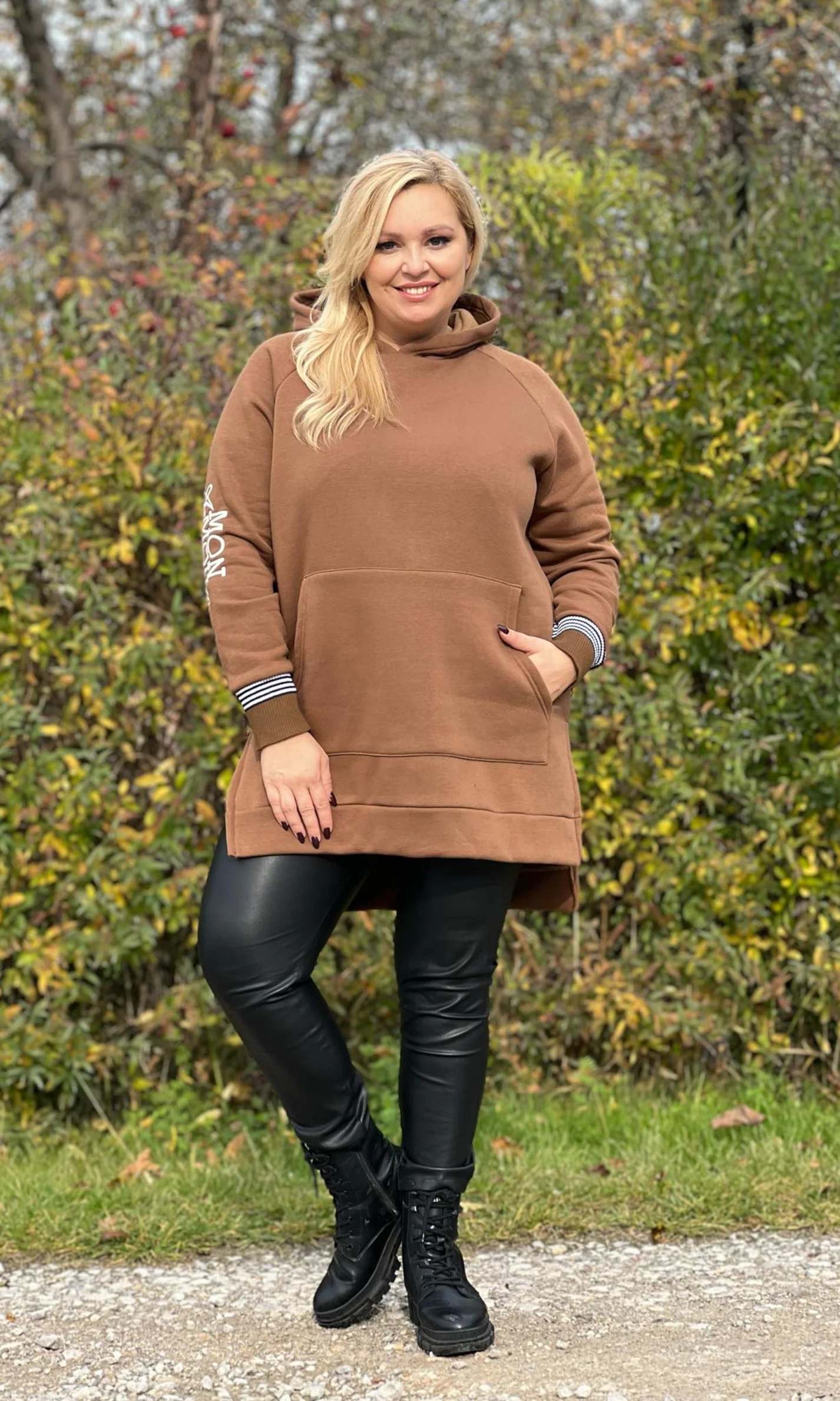 Woman wearing a hoodie dress with leggings and ankle boots