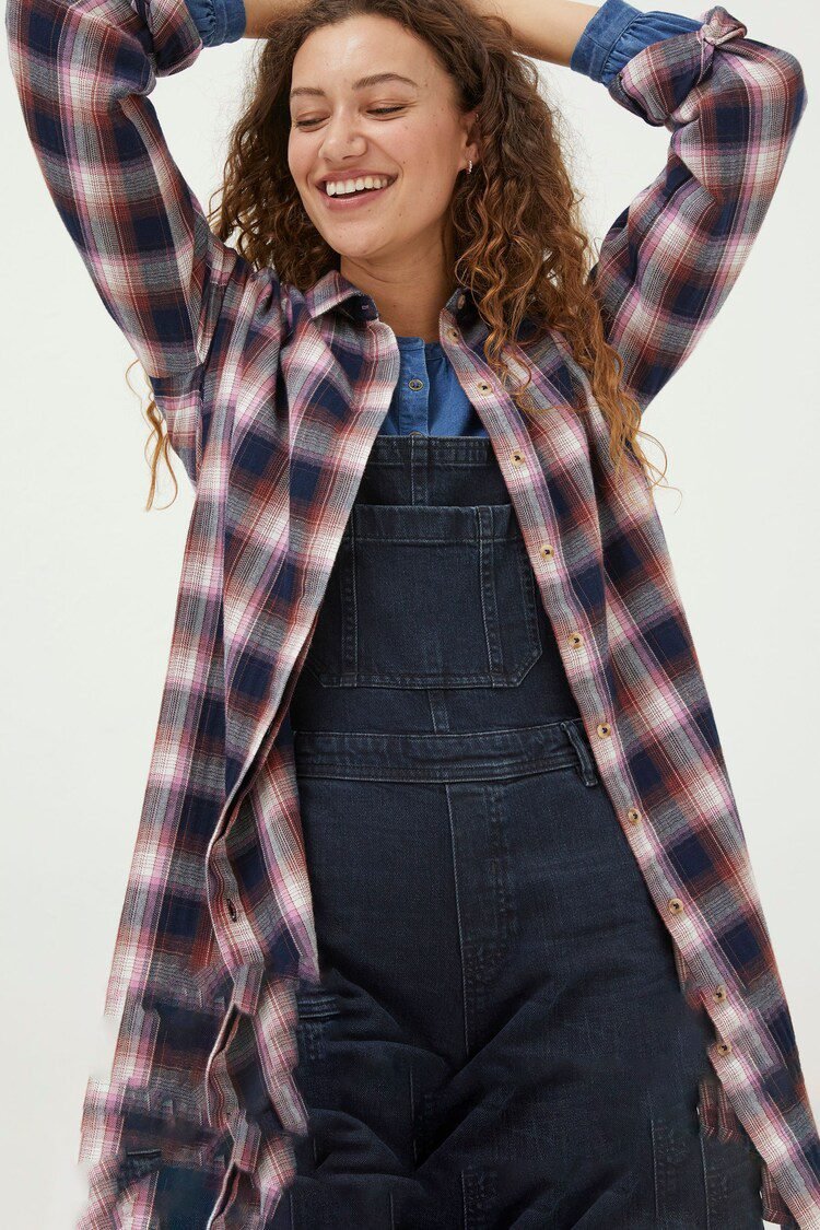 Woman wearing flannel shirt with denim overalls