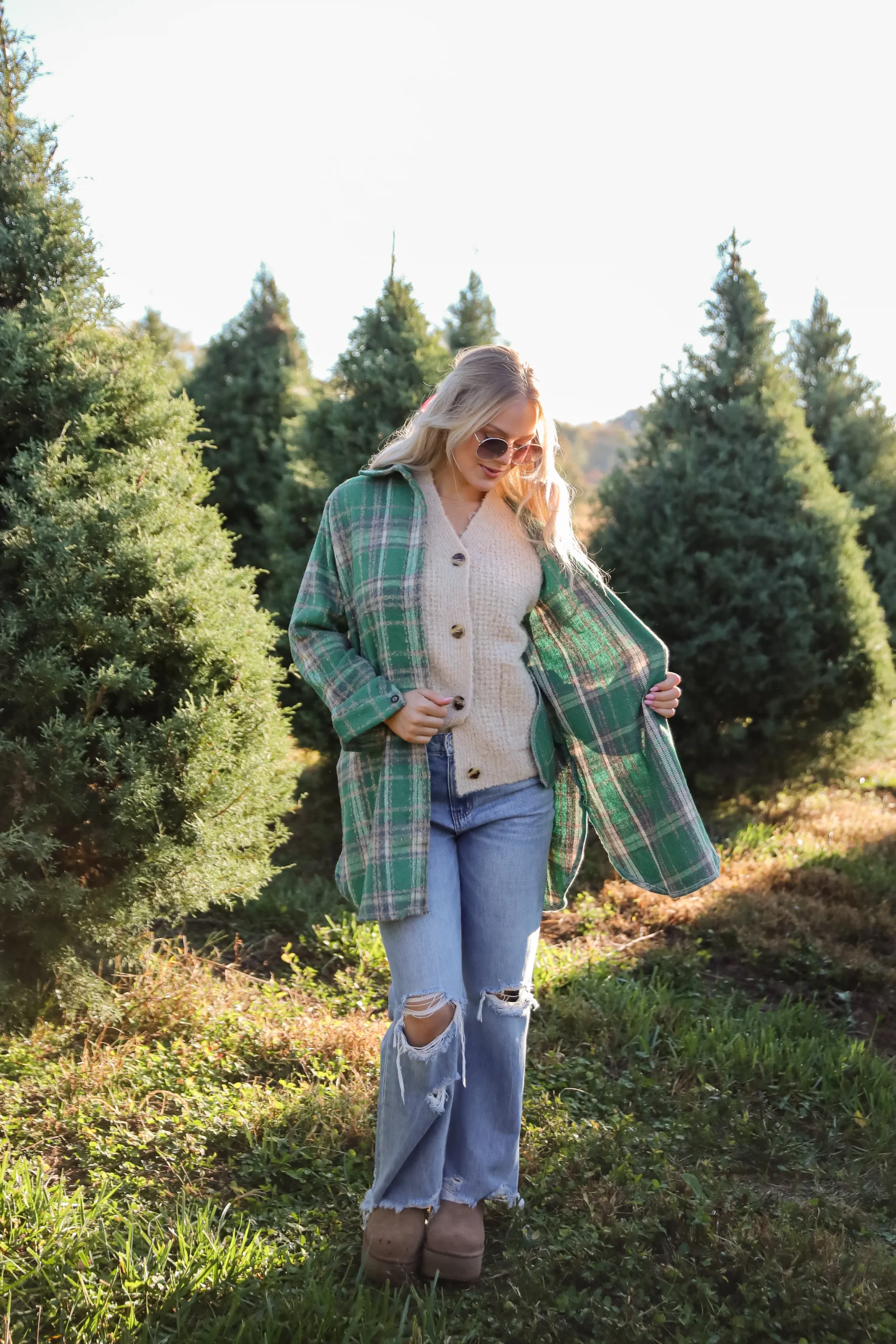 Woman wearing flannel with a cardigan and bootcut jeans