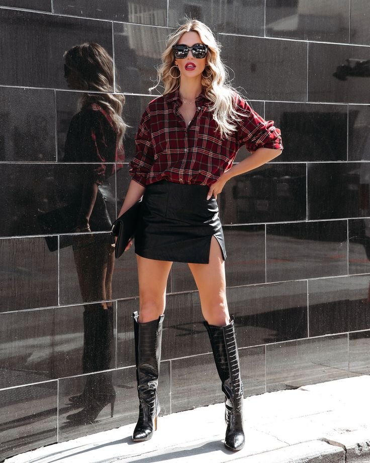 Woman wearing flannel with a faux leather skirt and boots