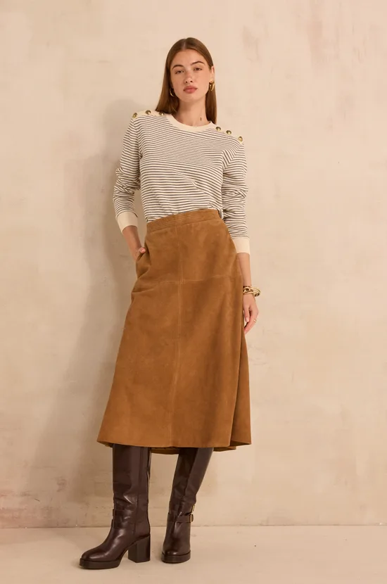 Woman wearing a striped sweater with a midi skirt and boots