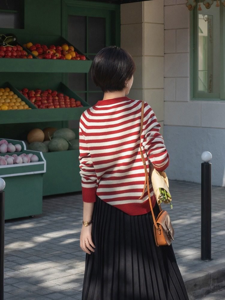 Woman in striped sweater with midi skirt and sneakers orchard