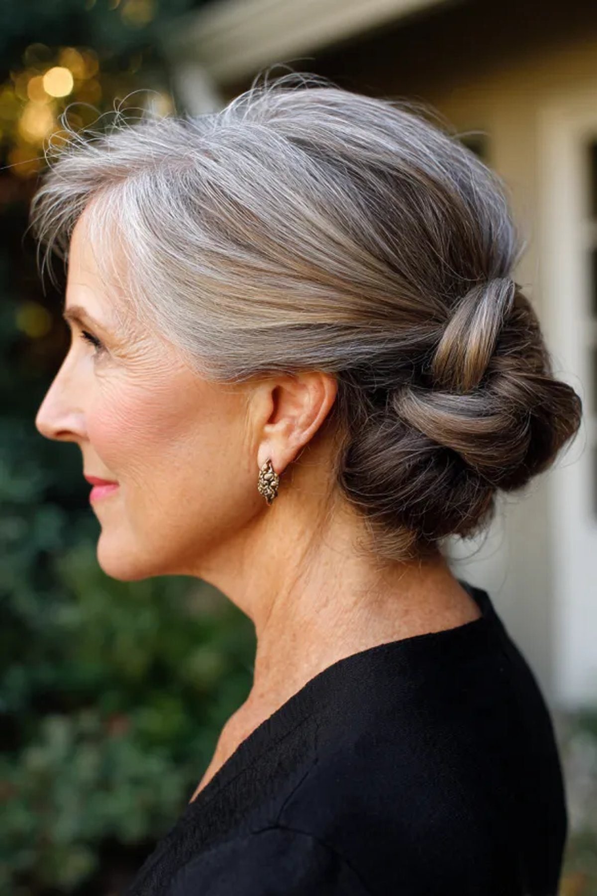 Soft low knot bun hairstyle on a woman over 60