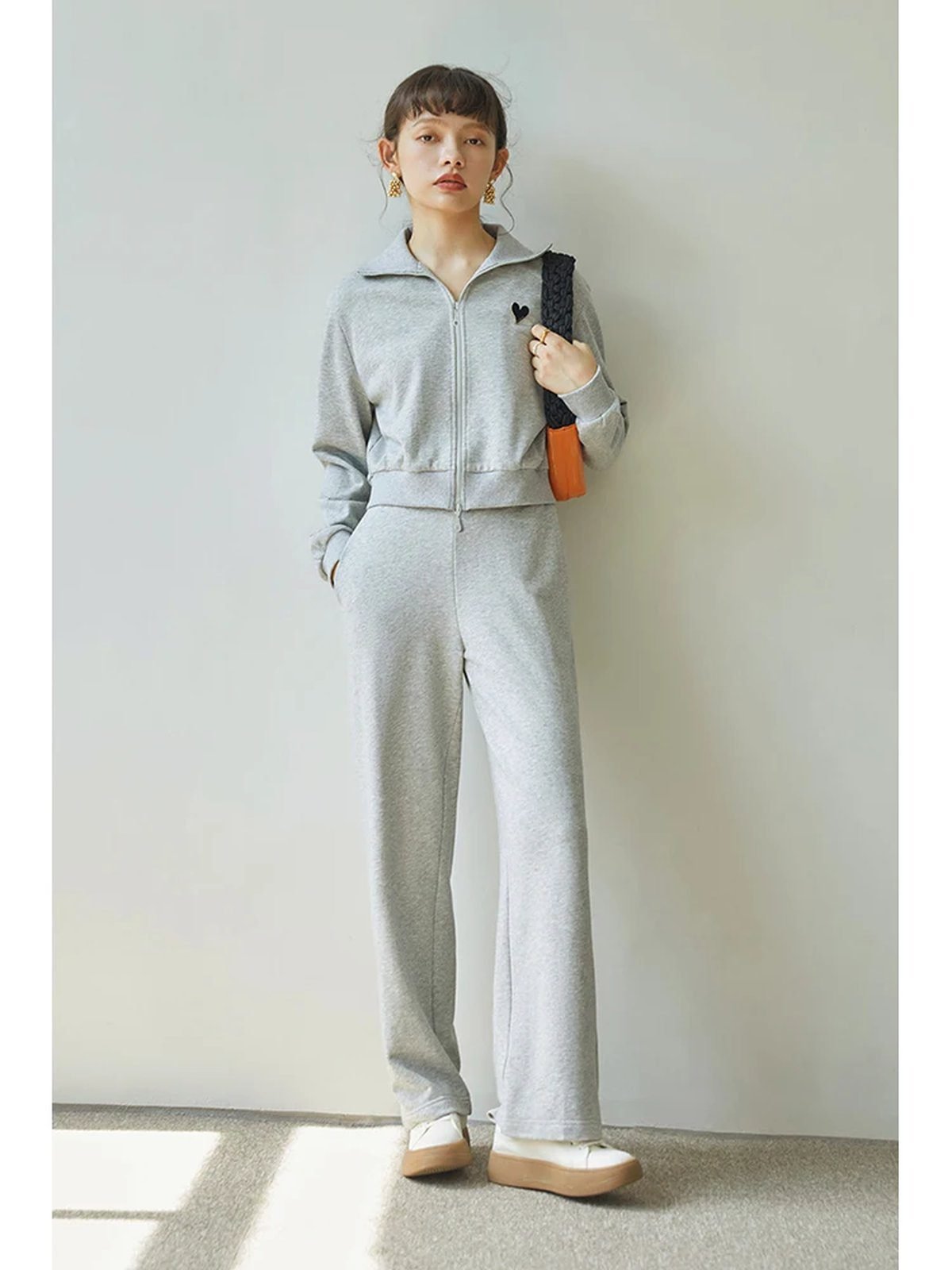 Woman in wide-leg sweatpants with a cropped jacket, cozy travel outfit