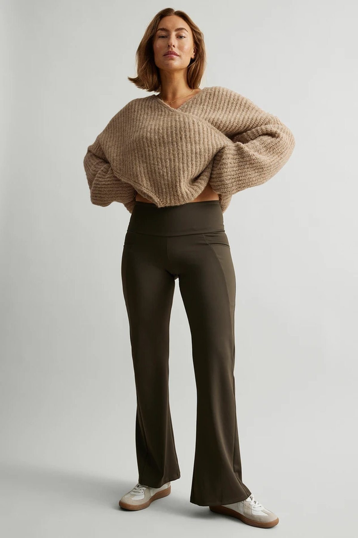 Woman in flared leggings with an oversized sweater, comfy travel outfit