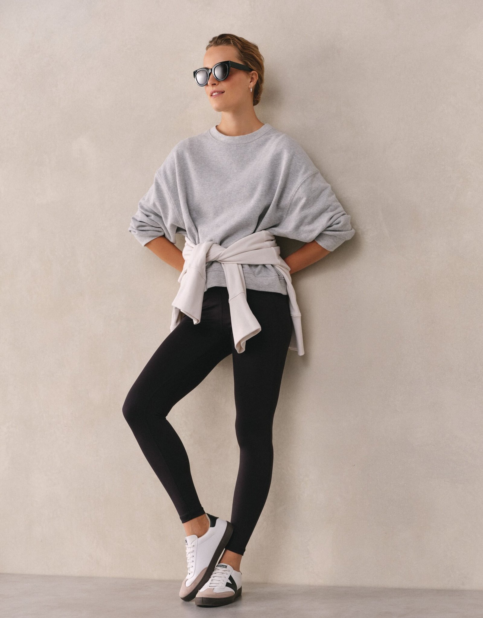 Woman in a crewneck sweatshirt with high-waisted leggings and sneakers