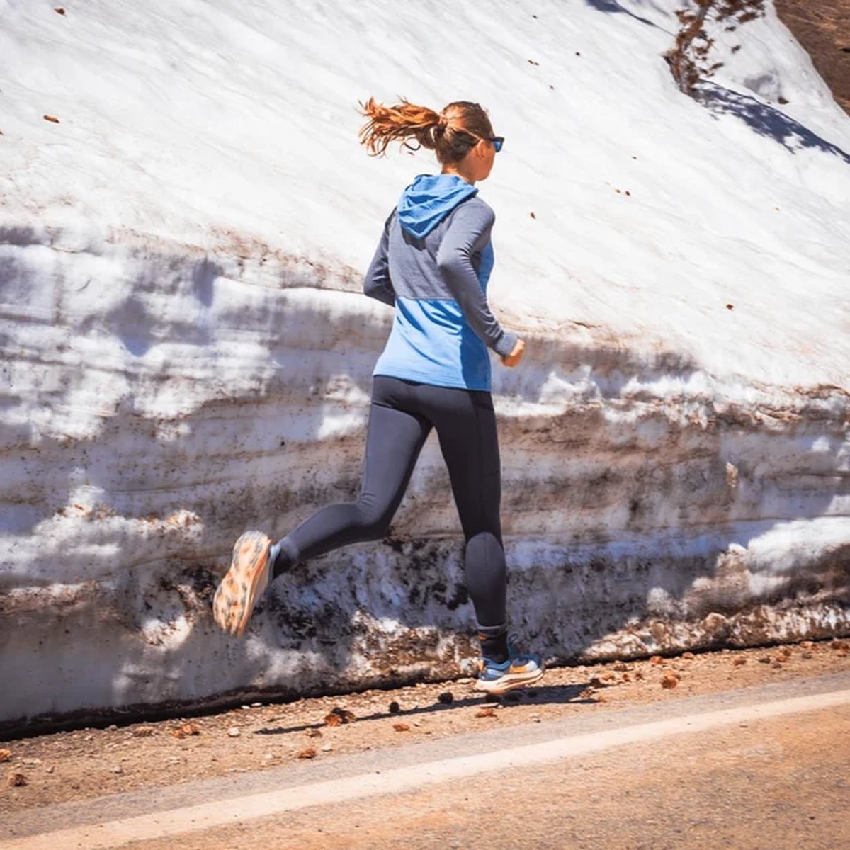 Woman running in a merino wool base layer outfit in cold weather