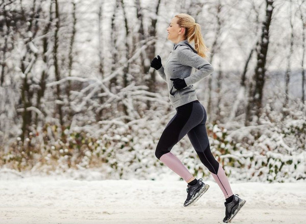 Woman in windproof running pants with a thermal top in winter