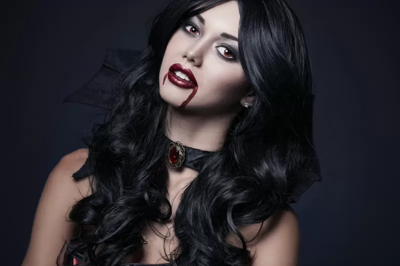 Woman in a vampire Halloween costume with dark red lips