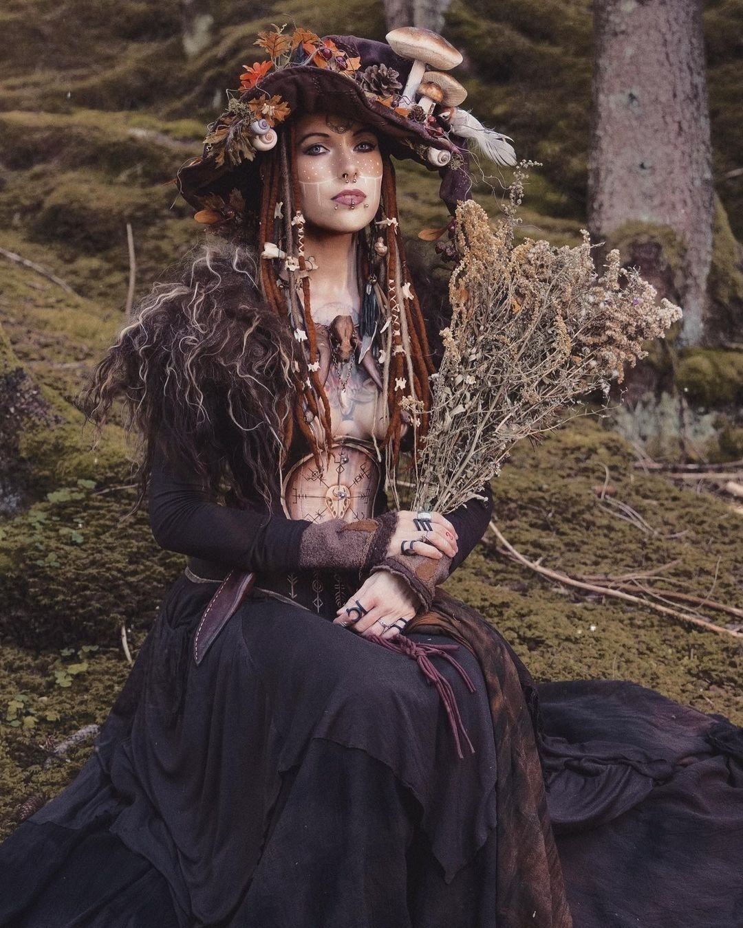Woman in a forest witch Halloween costume with natural elements