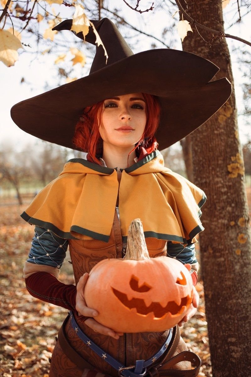 Woman in a fall pumpkin-themed witch Halloween costume